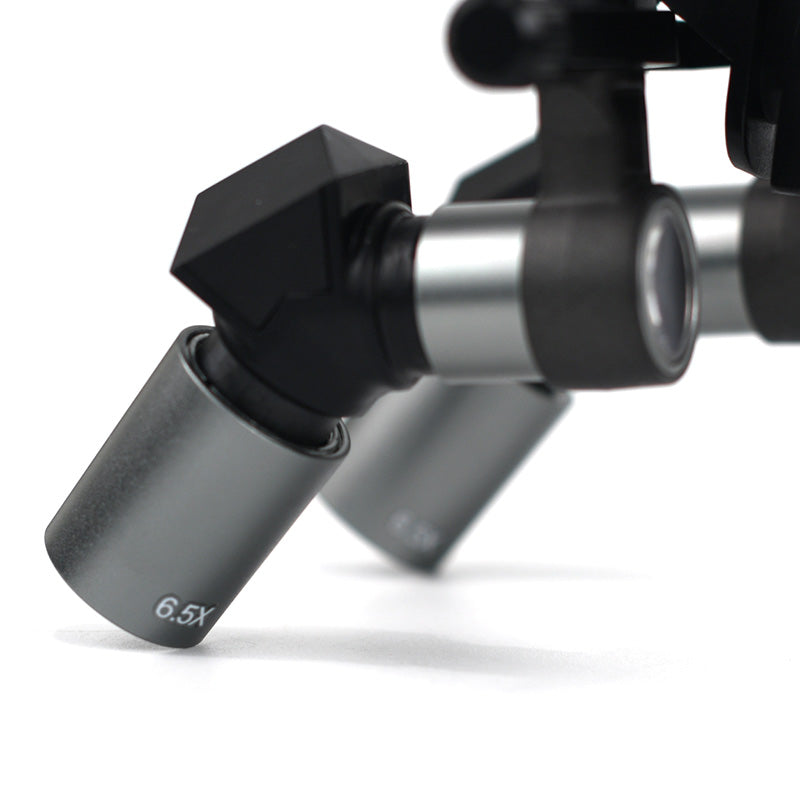 Close-up view of ergonomic deflection prism and 6.5x magnetic interchangeable metal lens barrel for surgical dental loupes