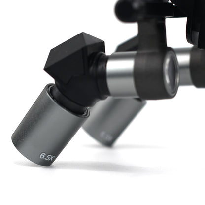 Close-up view of ergonomic deflection prism and 6.5x magnetic interchangeable metal lens barrel for surgical dental loupes