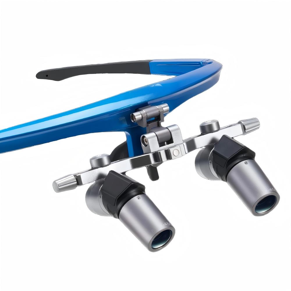 A high-resolution photograph of a professional blue-frame ergonomic 45-degree deflection flip-up loupe system, showcasing the specific refractive optics designed for neutral neck positioning and precise flat-panel viewing. Key visible features include the flip-up hinge, adjustable interpupillary distance (IPD) knobs, and the precision 3.0x to 6.0x magnification barrels.