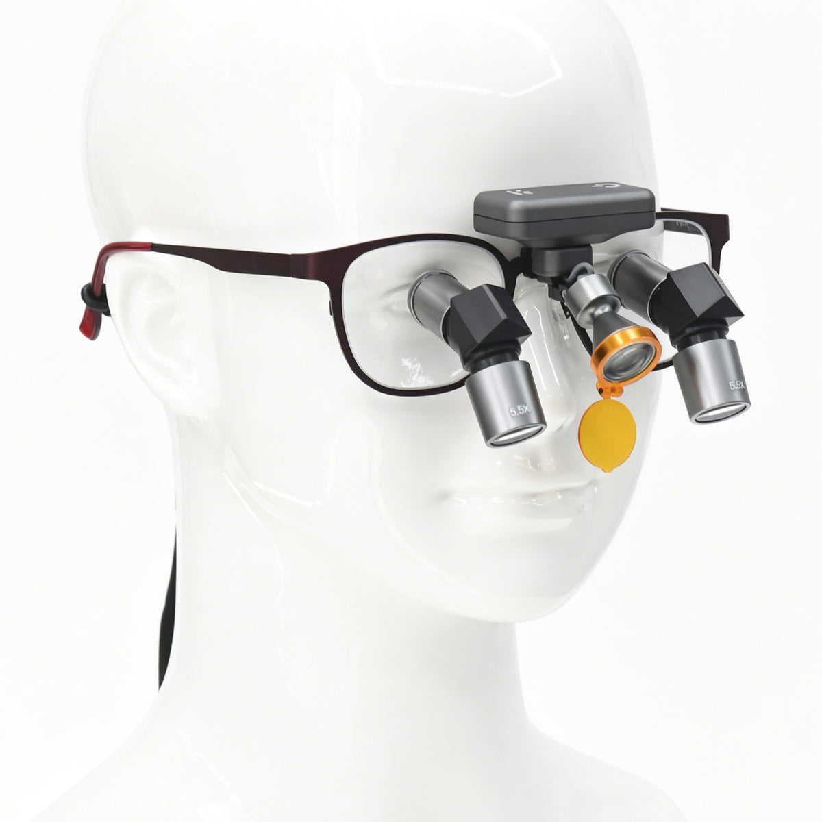 Front wearing view of wireless dental LED headlight attached to ergonomic loupe frame on medical mannequin model