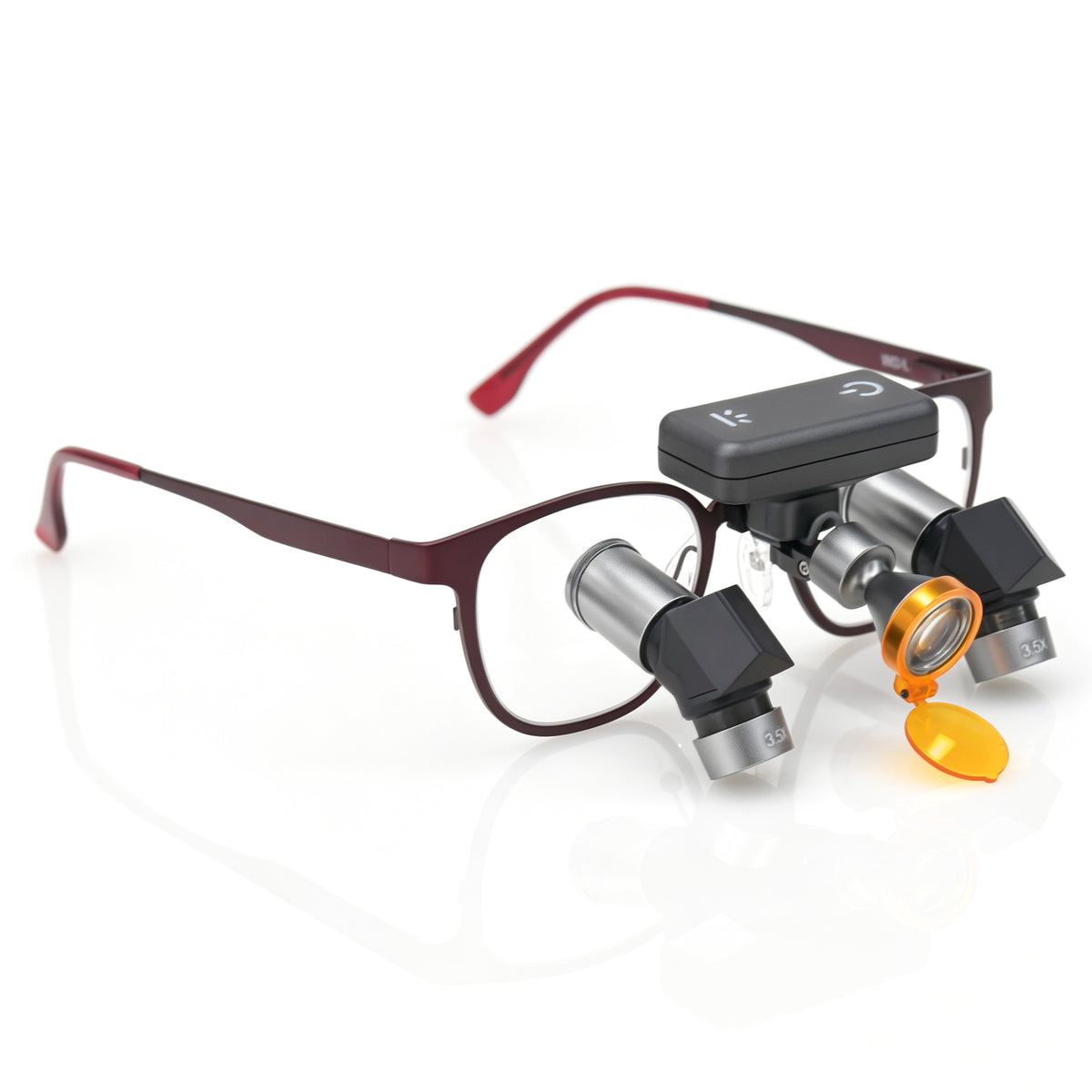 Compact wireless LED headlight mounted on ergonomic dental loupe frame featuring flip-up yellow curing filter for surgical illumination
